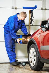 auto mechanic at car headlight checkup